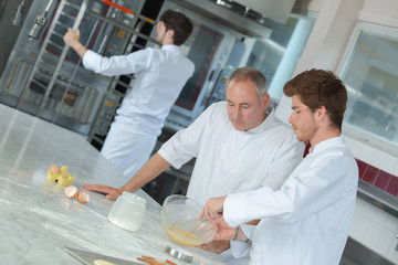 head-chef rating plate of one of his apprentices in kitchen