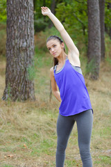 Woman stretching in the woods