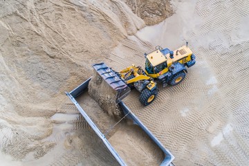 Wheel loader loading sand on dumper truck