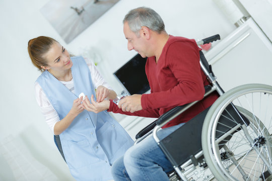 close-up of doctor giving disabled patient medicament