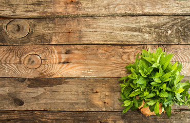 Bundl of mint on old wooden background. Copy space. Top view.