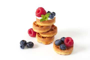 Pile of Belgian waffle with blueberry, raspberries and fresh mint Isolated