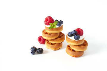 Pile of Belgian waffle with blueberry, raspberries and fresh mint Isolated