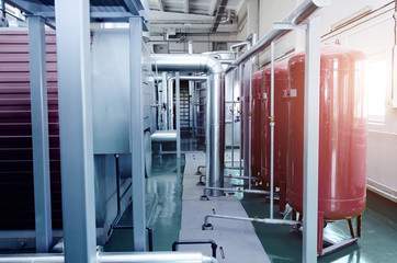 The interior of a modern industrial gas boiler room. Pipelines, water pumps, valves, manometers.