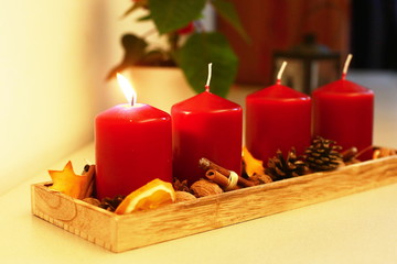 Four red advent candles on wooden rectangle plate