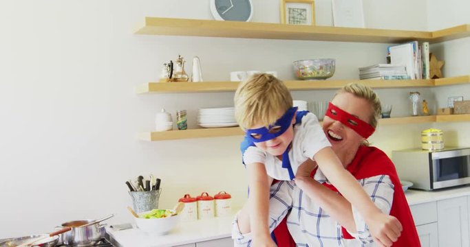 Mother and son pretending to be superhero in living room 