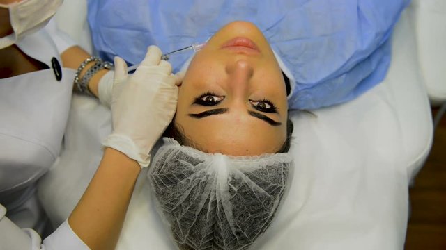 Young woman having a botox injection at beauty salon.