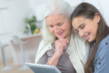 grandmother and grand daughter watching tablet