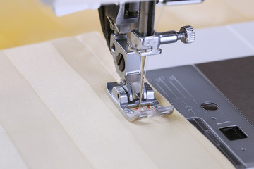 The sewing process, on an electric sewing machine. Household.