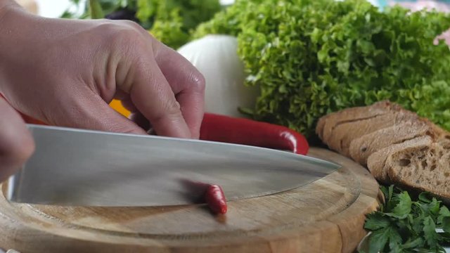 Man's hands chopping red pepper.
