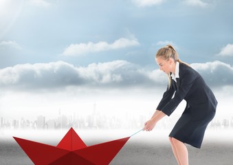 Obraz premium Businesswoman pulling paper boat with rope in city