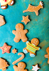 Fototapeta na wymiar Ginger men with colored glaze on a turquoise background .. Gingerbread. Christmas cookies. Ginger man in a colored sweater.