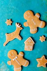Fototapeta na wymiar Ginger men with colored glaze on a turquoise background .. Gingerbread. Christmas cookies. Ginger man in a colored sweater.