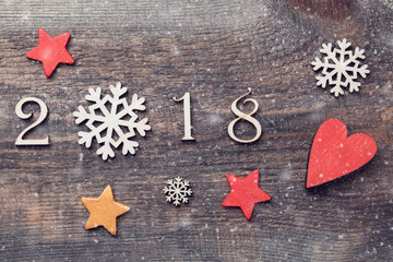 Happy New Year 2018 of real wooden figures with snowflakes and stars on wooden background with snow