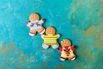  Ginger men with colored glaze on a turquoise background .. Gingerbread. Christmas cookies. Ginger...