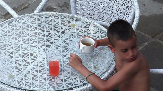 Naket little child boy sneeky drinks forbiden lemonade drink on 