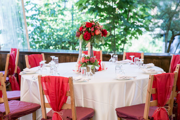 wedding table decorated with red coloured chairs