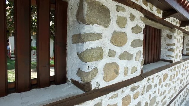 Walking along Stone Wall with ancient windows, 4k steadicam pov