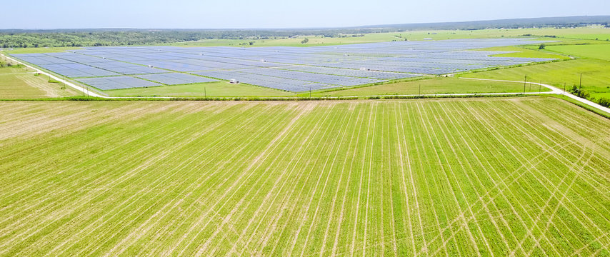 Panorama Aerial View Of Solar Farm Near Austin, Texas, USA. Renewable Energy Background.