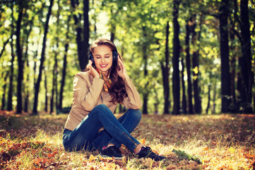 Young  girl  in autumn park in headphones