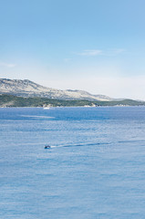 Obraz premium Greece Corfu, vertical view of sea with sun reflecting on seawater and boat passing by