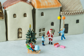 Selective focused on miniature figure Santa claus giving present to happy children as christmas celebration concept