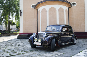 Old Mercedes car in front of church - obrazy, fototapety, plakaty