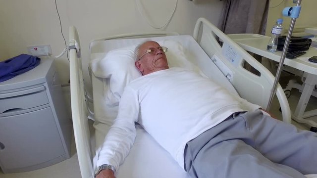 Old man resting in a hospital bed