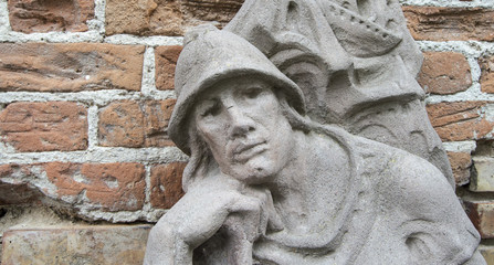 Sculpture the Thinker. A bas-relief of the thinker against a brick wall background.