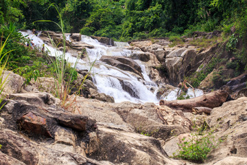 Stones against Cascade of Waterfalls in Tropical Park