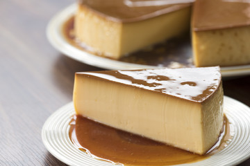  Homemade caramel custard pudding on white plate stay on wood table