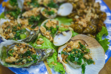 Fototapeta na wymiar Fresh oysters in a plate with spice and lemon