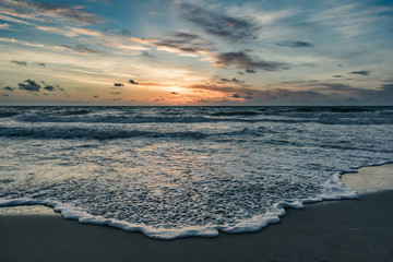 blue morning at the beach as the sun rises and the tides change