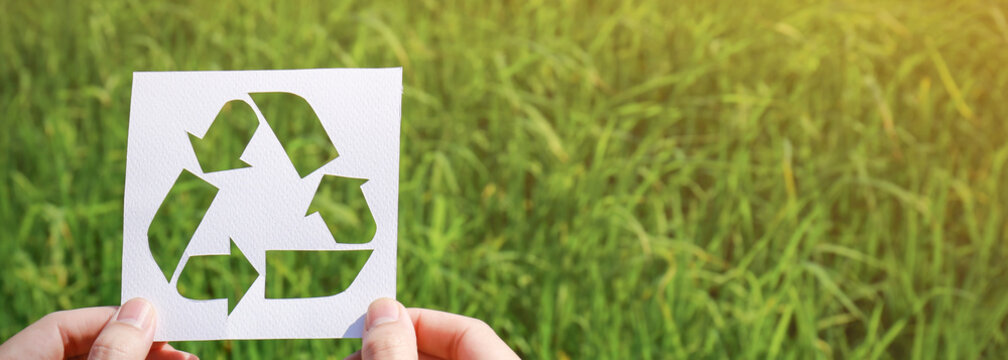 Cut paper with the logo of recycling over green grass. Recycling sign and  symbol background banner concept Stock-Foto | Adobe Stock