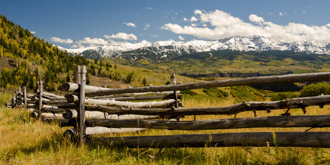 A fence backed by snowcapped peaks