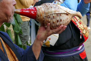 法螺貝を吹く男性