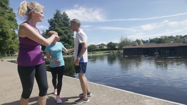  Healthy & active mature group running in the park stop for a chat