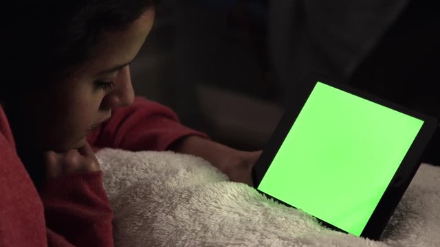 Woman watching tablet with green screen