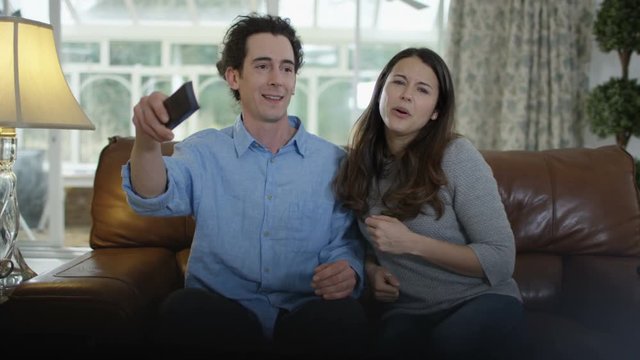  Couple fighting over the remote control in front of TV