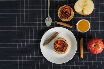 top view of apple pie rose form with cinnamon, apple juice and fresh apple