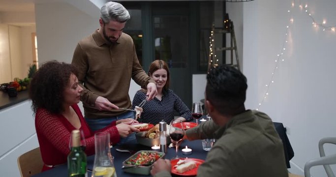 Adult male serving Christmas meal to friends