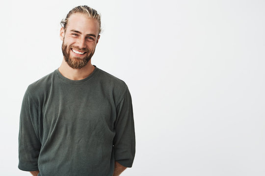 Portrait Of Cheerful Handsome Bearded Guy With Fashionable Hairstyle Smiling, Posing For Lookbook Shoot For Famous Fashion Brand.