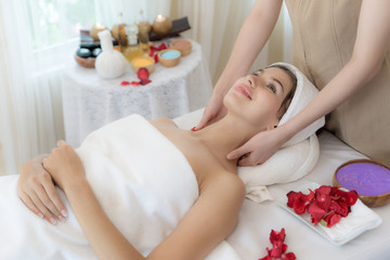 Obraz na płótnie Canvas beautiful and healthy young woman relaxing with face massage at beauty spa salon