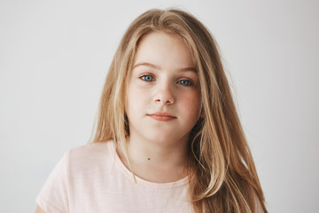 Close up of beautiful little blonde girl with light long hair and bright blue eyes. Child looking...