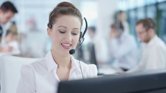  Friendly customer service adviser talking to a customer in busy call center