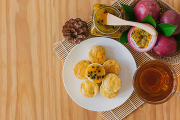 Homemade plain scones with passion fruit jam and tea. Scones is English pastry for afternoon tea or...