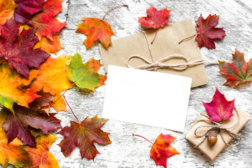 blank white greeting card wit gift box and autumn leaves
