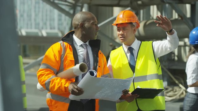  Multiracial team of engineers working together at construction site