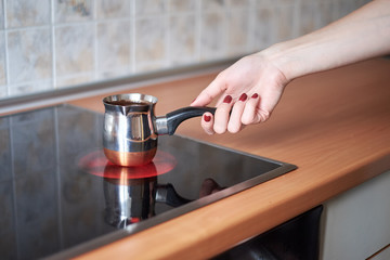 A picture of a young women preparing coffee in the kitchen in the morning