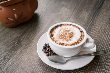 Coffee cup and coffee beans on wood table ,warm and good smell
